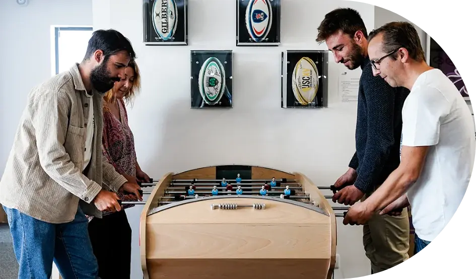 Photo de l'équipe de Hego Tech en pleine partie de babyfoot, reflétant l'esprit convivial et soudé qui anime notre entreprise. Un moment de détente partagée, illustrant la cohésion et la bonne humeur au sein de l'équipe.